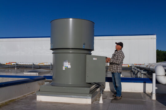 man inspecting exhaust fan