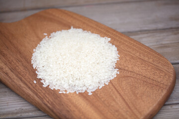 Fototapeta na wymiar A small pile of white rice on a cutting board