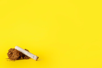 Cigarette and tobacco on color background