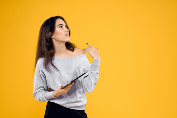 brunette with tablet in hands emotions internet technology yellow background