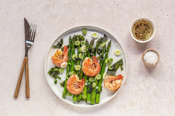 Seasonal salad from prawn shrimp, green asparagus, onion, and seaweed on a plate. Clean healthy eating.