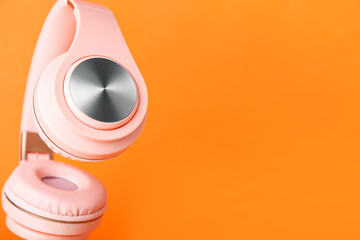 Modern headphones on color background