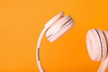 Modern headphones on color background