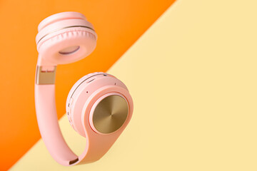 Modern headphones on color background