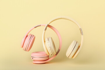 Modern headphones on color background