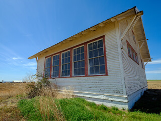 Fototapeta na wymiar An abandoned schoolhouse remains standing in a farm field in southeastern Washington, USA