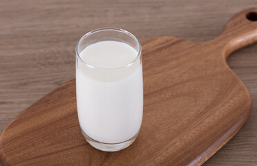 A glass of milk on a chopping board