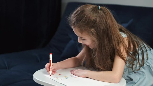 Little girl writing a post card for a holiday
