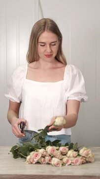 Woman ctting and sorting roses in flower shop