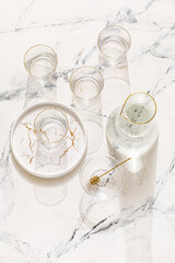 Obraz na płótnie Canvas Beautiful empty glasses, jug and plate on light background