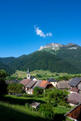 Paysage du Parc Naturel Régional des Bauges avec le village de La Compôte entouré de montagnes en Savoie en france au printemps