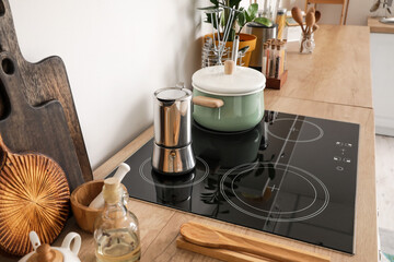 Modern electric stove and utensils in kitchen