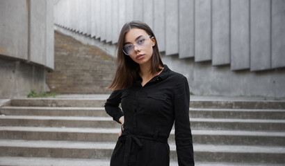 Fashion portrait of a sexy brunette woman with a make up wearing black clothes. She is wearing...