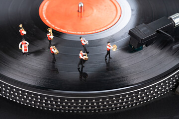 Miniature musicians on turntable top view 