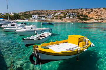 Small fishing boats suspended in the transparent water of the port of the Greek island of Irakleia...