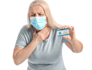 Ill senior woman with vaccination card on white background