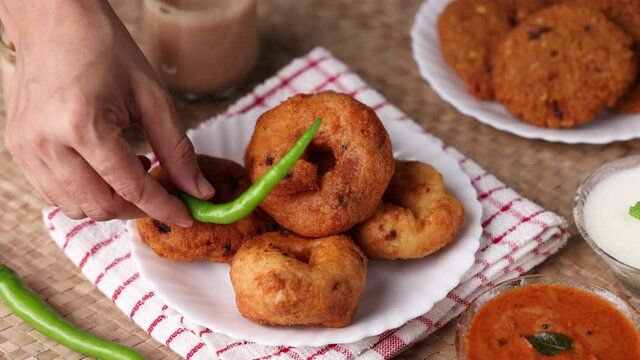 Medu Vada with tiffin sambar coconut chutney in traditional background , savory fried tea time snack of Kerala, Tamil Nadu South India.  Indian veg breakfast food 4K slow motion video footage.