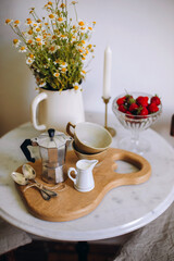 steel moka pot with two cups and two spoons on a wooden board. preparing for breakfast with fresh coffee. morning with coffee in Italian style