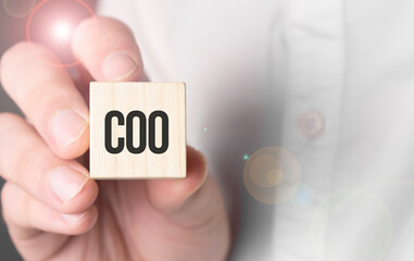 Man holding coo word on wooden cube.