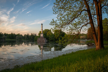 View of the Chesmenskaya Column in the center of the Large Pond of the Catherine Park in the rays...