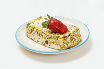 Halva with pistachios on plate on white background