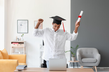 Happy African-American student on his graduation day at home. Concept of online education