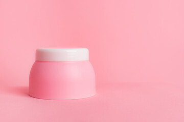 Pink jar with cream on a pink background . Cosmetology. Skin care. Article about the choice of cream. Article about the choice of care cosmetics. Spa treatments.