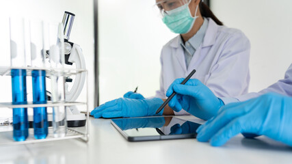 Team of Medical Research Scientists or researcher in lab coat testing their experimental in Modern...