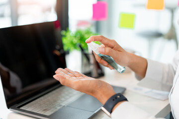 a male freelancer using alcohol rubbing his hands preventing the germ while working with others