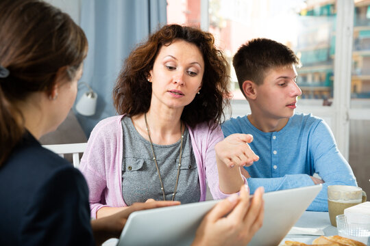 Woman And Teenage Son Meeting With Female Teacher At Home