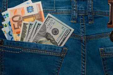 dollar and euro, bills in the pocket of jeans. The concept of pocket money. Cash. American and European money. business, trade or financial transactions, seasonal discounts. close-up