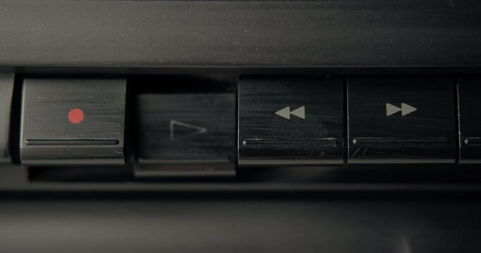 Your finger presses the rewind button then presses the play button. Old dusty cassette recorder.