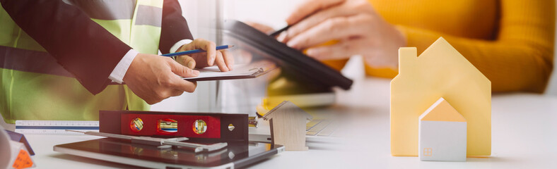 Engineers or architects is watching on model building and blueprint in working site.Construction and structure concept.