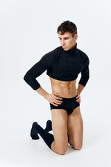 man with a pumped-up torso in shorts and in black socks posing 