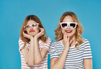 two cheerful women in striped t-shirts summer style blue background