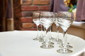 Empty glasses stand on a table in a restaurant on a white tablecloth. Table setting in the restaurant, bar and cafe