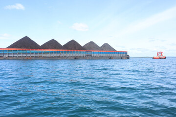 a tugboat pulling a coal pontoon in the sea area of ​​Jakarta, Indonesia