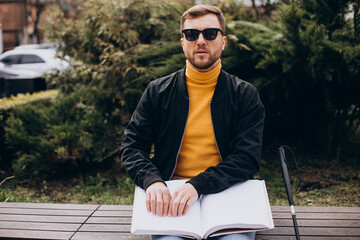 Blinded man reading braille book