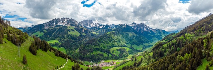Fototapeta na wymiar View on alps mountains, green fields, cloudy sky by Jaun, Jaunpass. Canton Fribourg, Freiburg nearby Bulle, Bern, Thun. Good hiking tourist way. Switzerland.