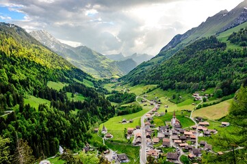 View on alps mountains, green fields, cloudy sky, Church by Jaun,  Jaunpass. Canton Fribourg,...