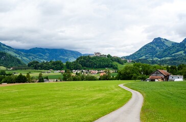 Fototapeta na wymiar View on alps mountain, green fields Bulle, kanton Fribourg, Freiburg nearby Bern. Castle Greyerz Good hiking tourist way. Switzerland.