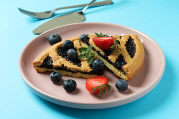 Concept of delicious food with blueberry pie on blue background