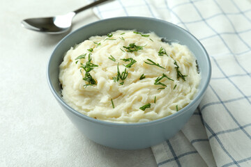 Bowl of mashed potatoes on white textured background