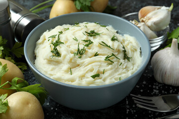 Concept of tasty eating with mashed potatoes on black smokey table