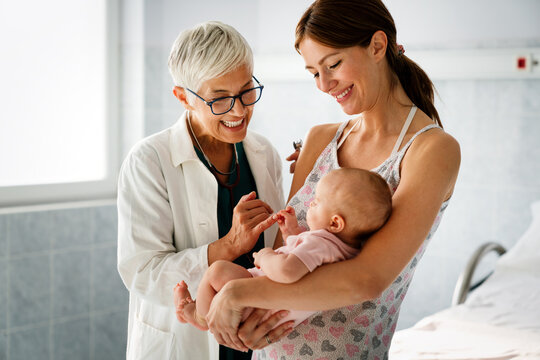 Happy Pediatrician Doctor With Baby Checking Possible Heart Defect