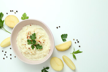 Plate of mashed potatoes and ingredients on white background