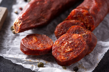Spanish chorizo sausage on black background. Close up