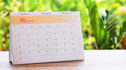 White desk calendar on a wooden table, planning ideas.
