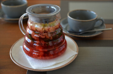 Teapot with apple, raspberry and mint fruit tea on table