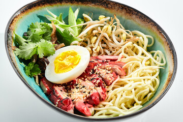 Ramen Chicken Soup - traditional soup with chicken and ramen noodles and other ingredients. Topped with eggs. Ramen soup bowl isolated on white background.